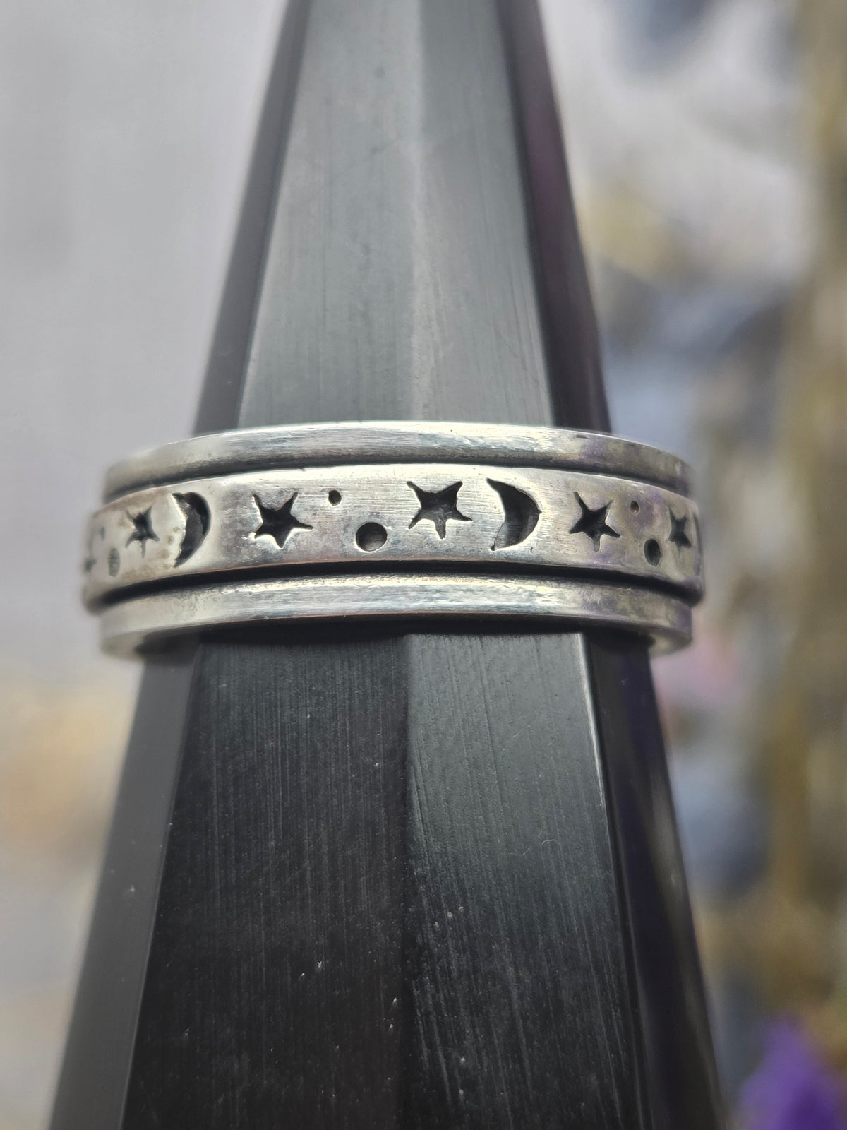 Sterling silver spinner ring with celestial design on a display stand