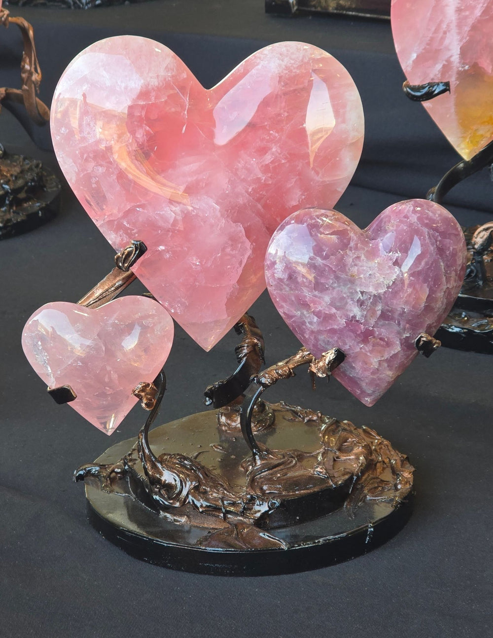 Pink crystal hearts displayed together at a gem show