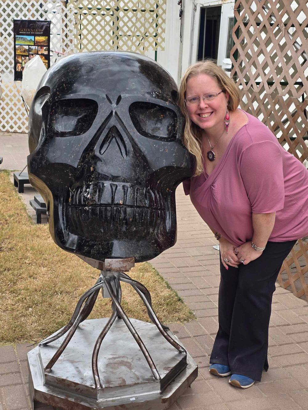 Stacy poses beside a giant black crystal skull at a gem show