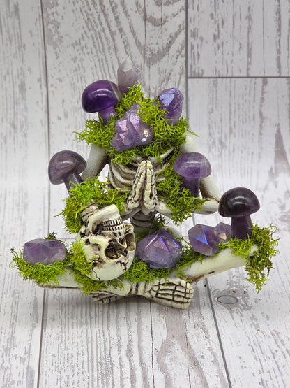 Crystal skeleton figurine with purple crystals and green moss