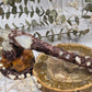 Handmade moonstone and clear quartz wand on a decorative background