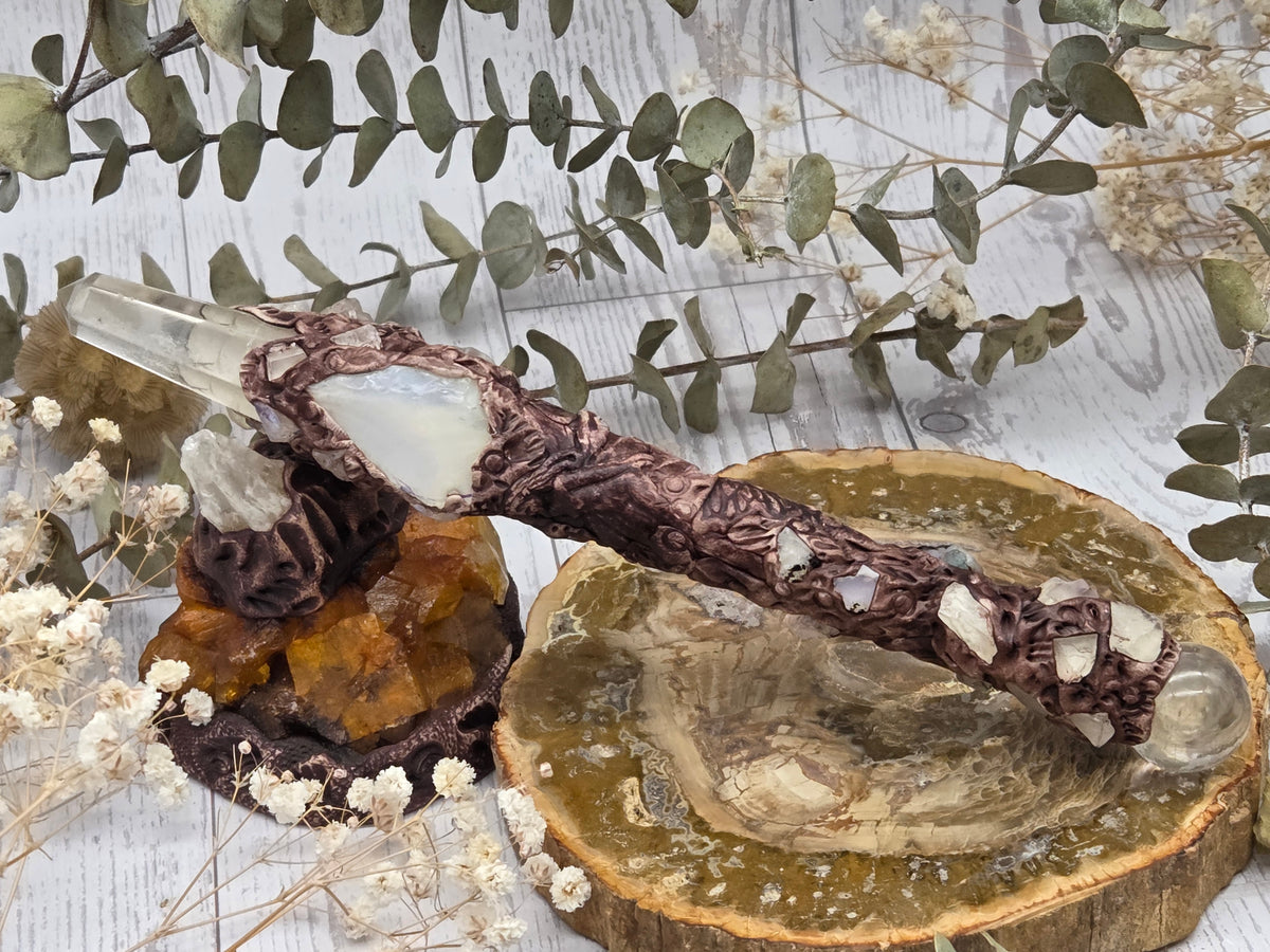 Handmade moonstone and clear quartz wand on a decorative background