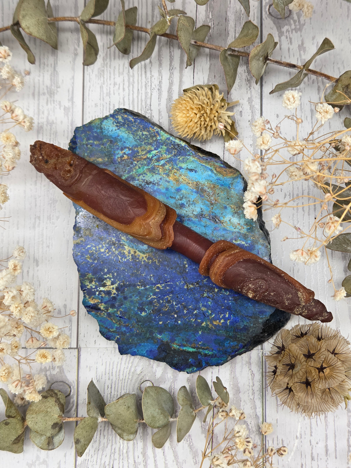 Gobi Desert Agate Wand on a blue stone background