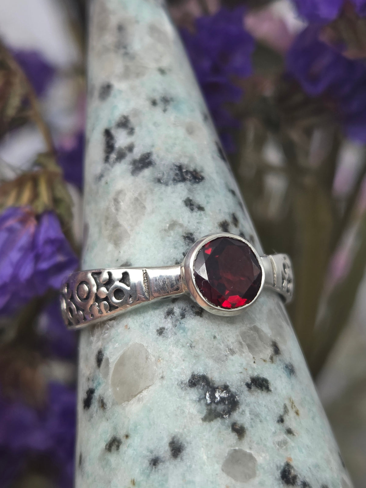 Garnet ring with red gemstone set in silver band