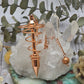 Copper pendulum with a polished finish on a crystal base