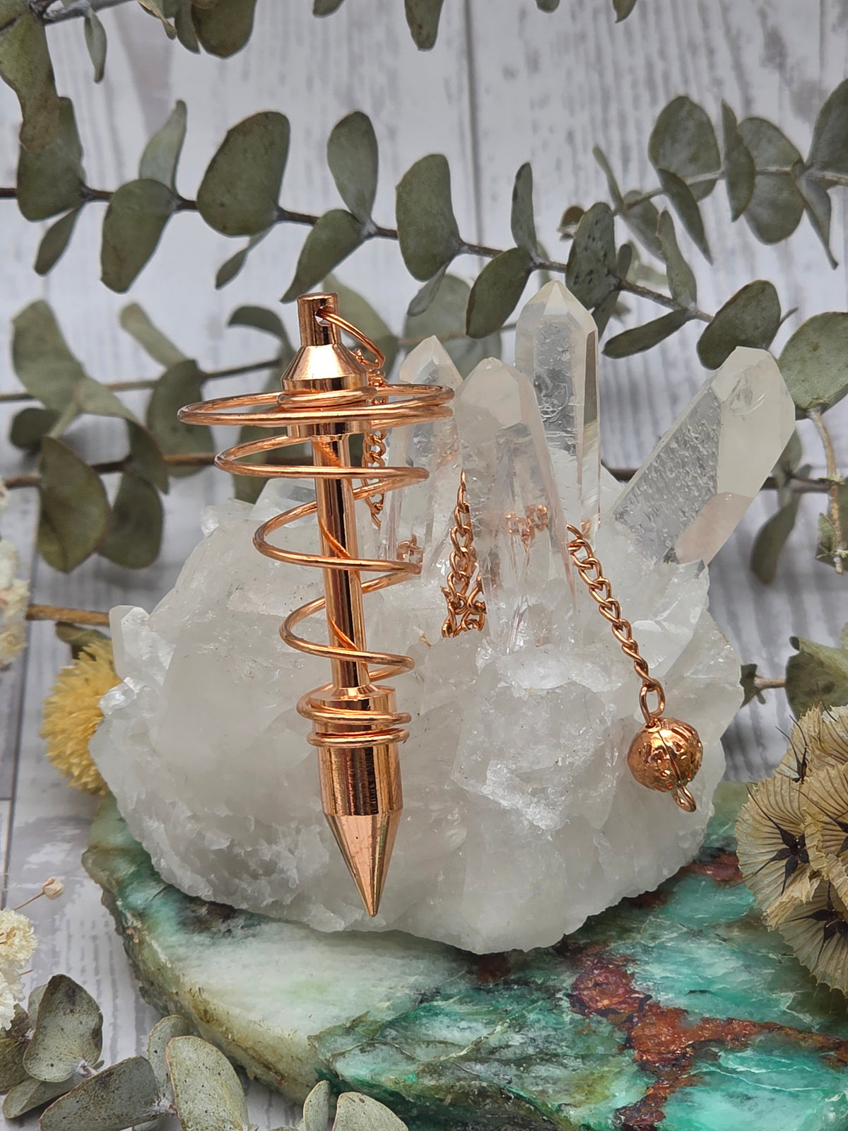 Copper pendulum with a polished finish on a crystal base