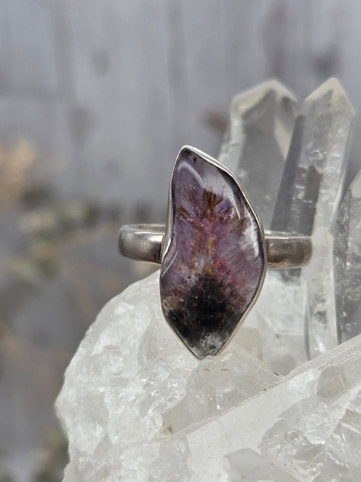 A Super 7 ring with a polished stone in purple and black hues.