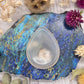 Flower Agate teardrop worry stone on a colorful background
