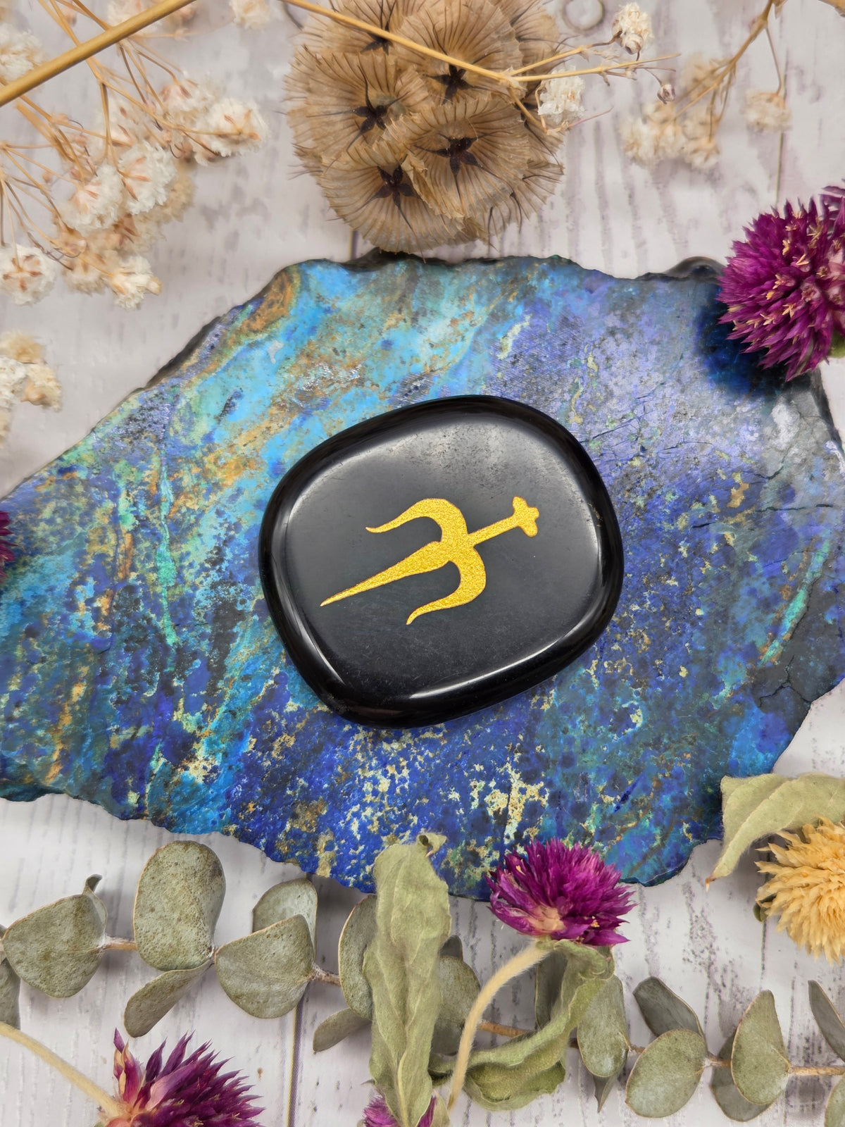 Obsidian etched pocket stone on a colorful background