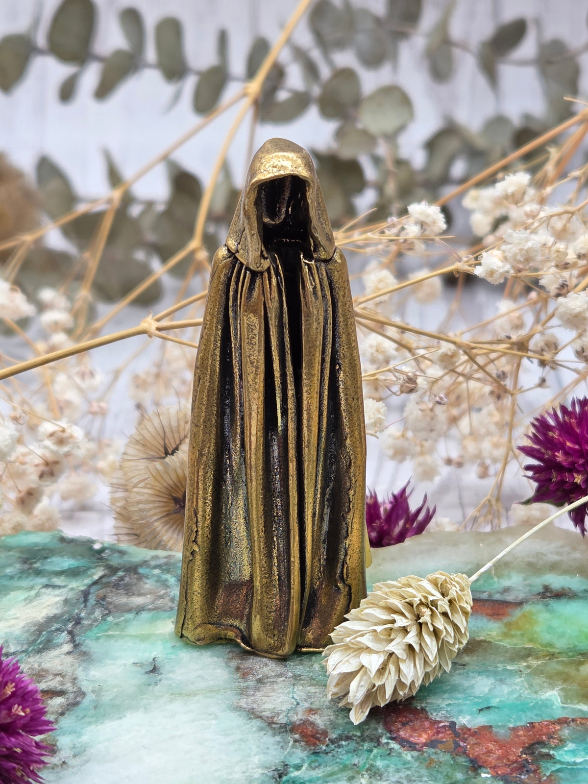 A small brass phantom figurine with a polished surface