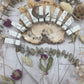 Howlite crow carving surrounded by dried flowers