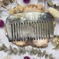 Water buffalo horn comb with polished surface on a wooden background