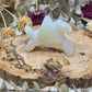 Opalite Pegasus figurine on a wooden base surrounded by dried flowers