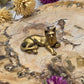 A small brass cat figurine with a polished finish