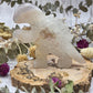 Agate dinosaur figurine on a wooden base with floral background