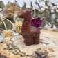Red Jasper giraffe figurine on a wooden base with dried flowers