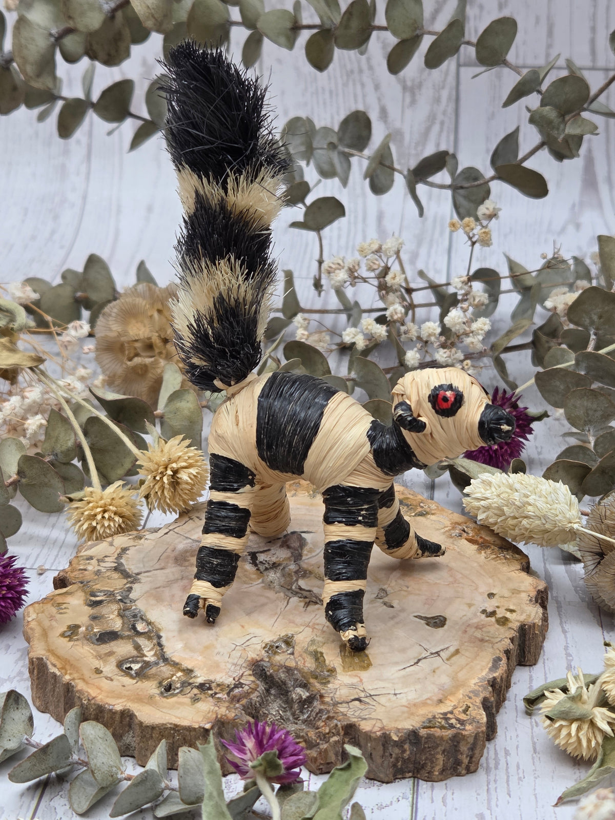 Banana fiber ringtail lemur figurine with beige and black colors on a wooden base