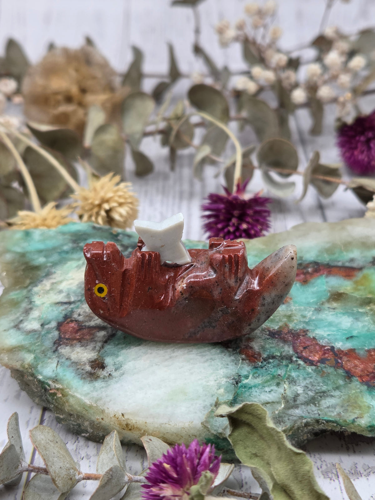 Soapstone otter figurine on a colorful stone background
