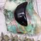 Rainbow Obsidian moon carving on a colorful stone background