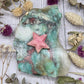 Pink rhodochrosite star carving on a green stone background
