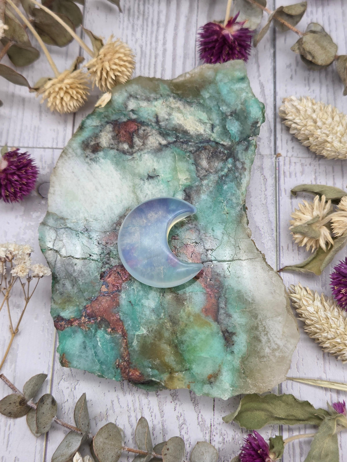 Opalite moon carving on a colorful stone background