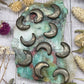 Set of pyrite moon-shaped beads on a colorful background