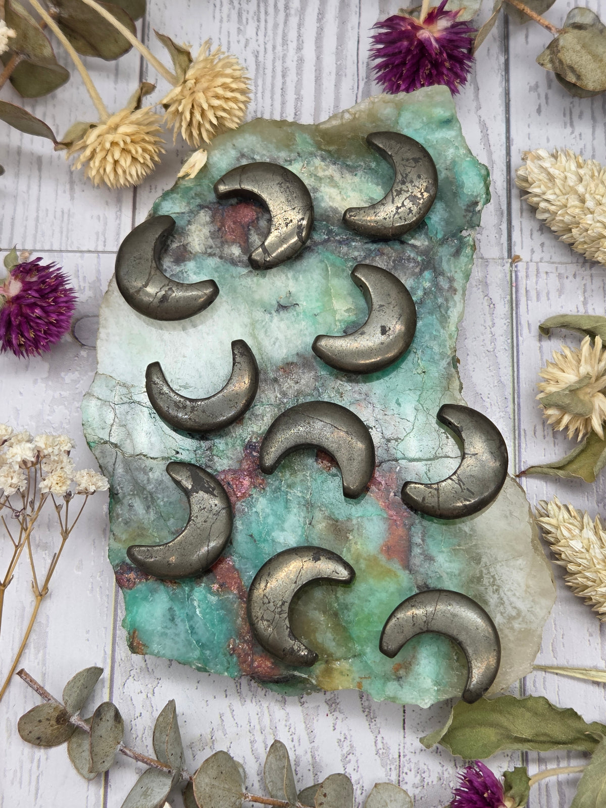 Set of pyrite moon-shaped beads on a colorful background