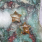 Golden Healer Quartz star carving on a colorful background