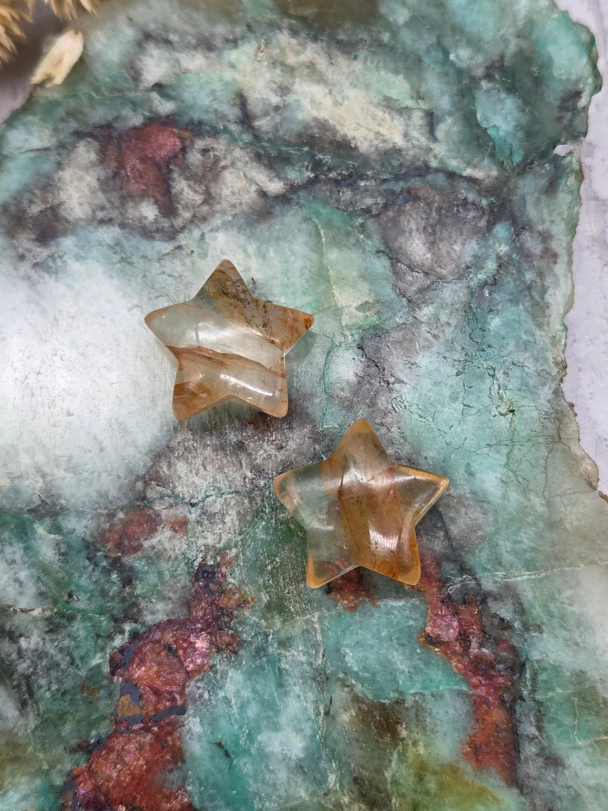 Golden Healer Quartz star carving on a colorful background