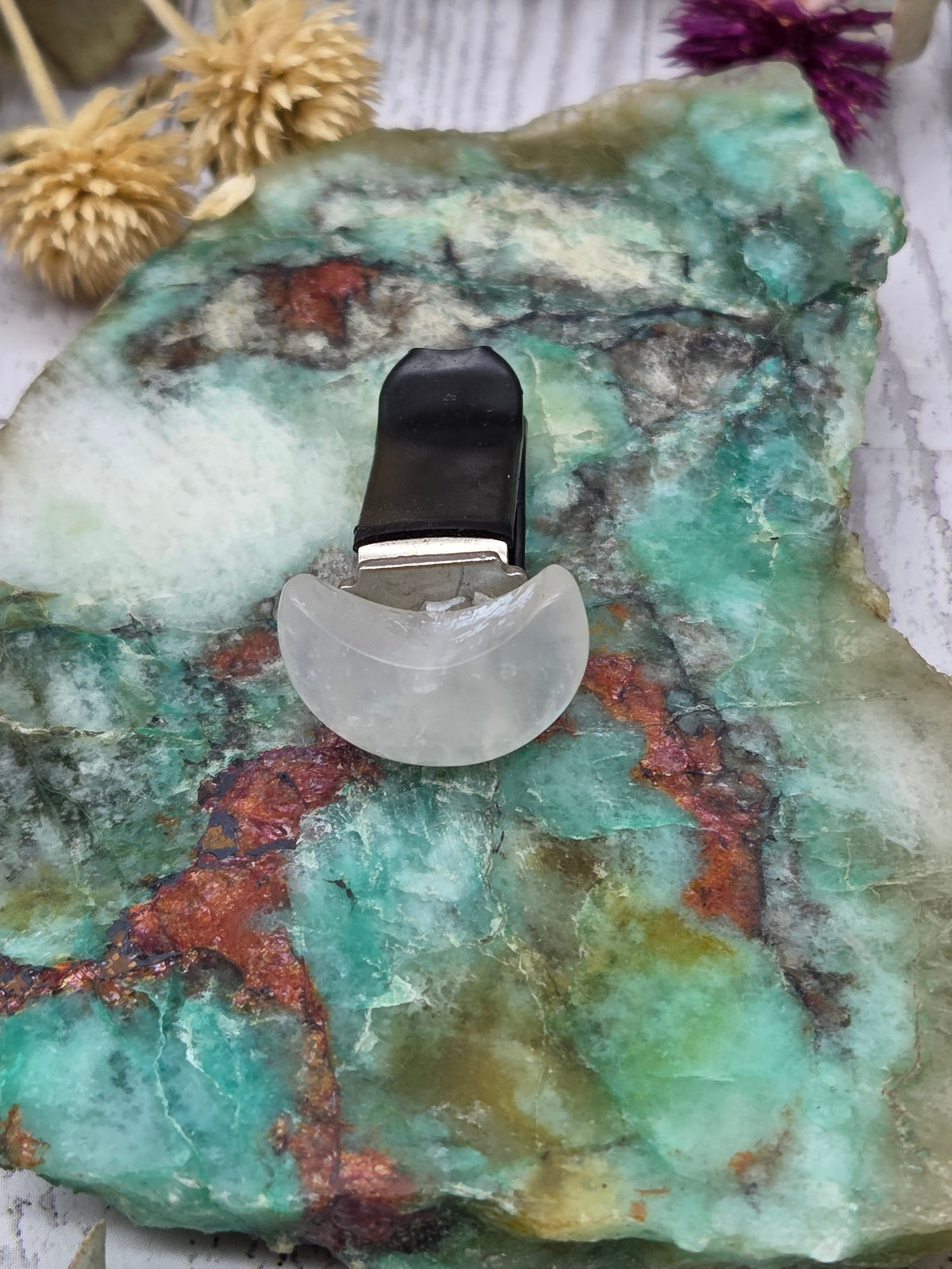 Rainbow Moonstone Car Vent Clip on a colorful stone background